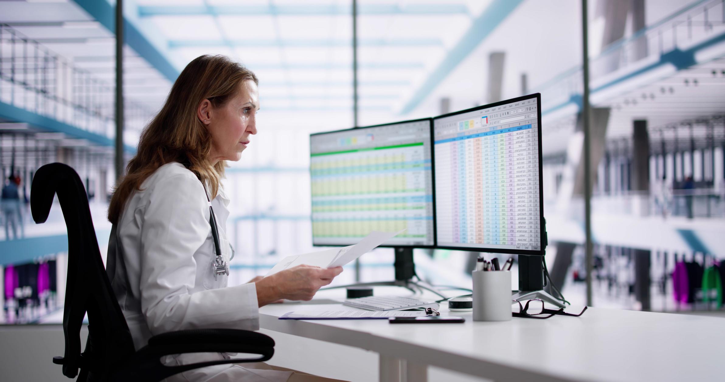 woman looking at data on computer screens